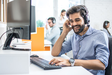 Smiling friendly helpline technical support operator in call centre