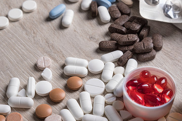 Close-up of pills lying on the table. Medical background from pills of different shapes and colors.
