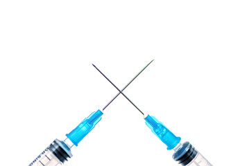 Two crossed syringes close up on white background.