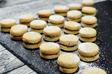 Traditional serbian homemade vanilla cookies, vanilice , with jam and powdered sugar, side view, close up, pattern food design