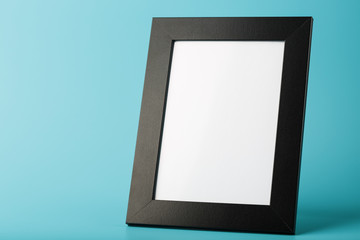 Black photo frame with free space on a blue background.