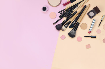 Colorful cosmetics lying on pink and yellow background. Flatlay