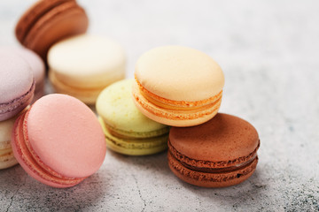 French macaroni cookies of different colors are on the gray table. Still life of confectionery.