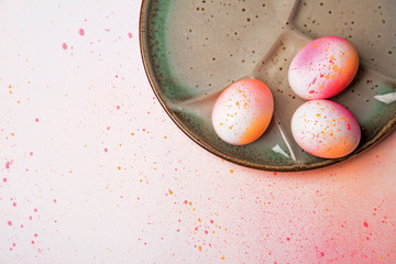 Hand painted easter eggs on ceramic plate pink orange shiny colored paint pattern © Maciek
