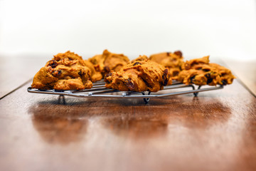 Pumpkin muffins with chocolate chips and raisins on cooling rack on rustic wooden table