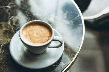 A cup of fresh fragrant morning coffee on a marble table