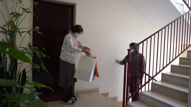 Senior woman receives delivery in apartment building