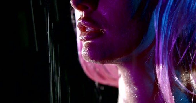 sensual lips of young sexy woman under water flows, closeup view, night rain
