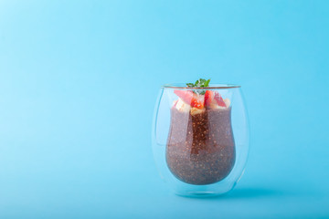 Chocolate Chia pudding decorated with strawberry on blue background