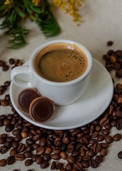 A cup of fresh espresso with chocolates. Coffee beans. Morning coffee concept