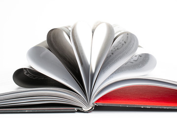 Opened book with folded, fanned pages frot view and selective focus as education, business and...