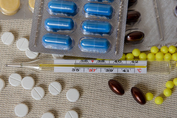  Various medicines in tablets and capsules. Mercury thermometer. Medicine concept. Pharmaceutical...