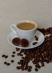 A cup of coffee for breakfast. Coffee beans. Espresso in a white cup.