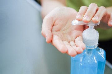 Closeup Women wash hands, blue alcohol gel bottles for cleaning and medical surgical masks for stop corona virus outbreak.Wuhan coronavirus and epidemic virus symptoms.