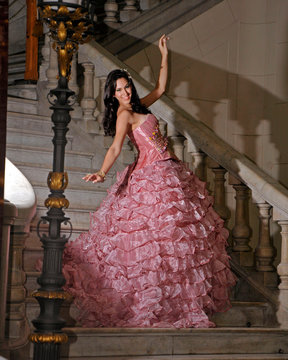 princesa bajando las escaleras en el museo con vestido rosa vieja con modelo alegre y feliz