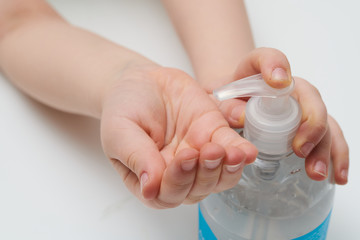 Child using pump bottle antibacterial gel close up