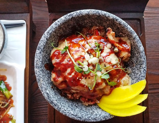 Top view of Japanese tori cheese don, grilled chicken on bed of rice, with yellow pickle, Mozzarella cheese and teriyaki sauce.