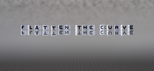 flatten the curve concept represented by black and white letter cubes on a grey horizon background stretching to infinity