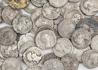 Antique Roman coins, a small pile of cash on a white background