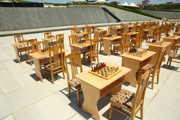 Yellow and brown photo with a picture of a chess Board pieces, Wooden pieces on a chess Board and emtye table . How to play wooden chess game. Chess board with yellow and brown figures .