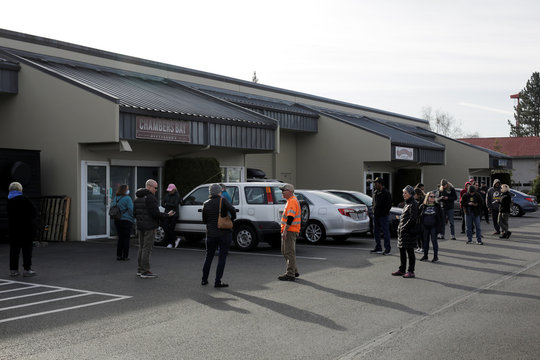People wait in line for free hands sanitizer at Chambers Bay Distillery, which is creating the product with ethanol alcohol and giving it away, following reports of coronavirus disease (COVID-19) cases in the country, in University Place