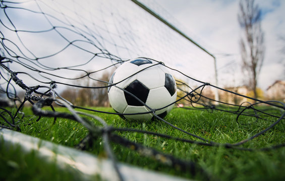 Goal Concept As A Soccer Ball Enters The Gate And Hits The Net. Football Championship Background, Spring Outdoors Tournaments On The Stadium. Healthy Sports Activity And Games.