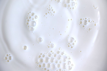 White surface of milk and bubbles and ripples from above birds eye view