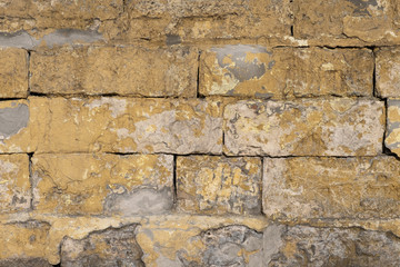 Old and traditionally wall made of cement and stone in various colors and shades. Vintage wall from stones of various shapes, close-up architectural background.