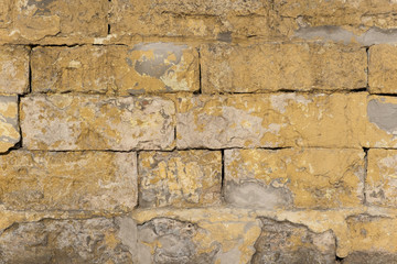 Old and traditionally wall made of cement and stone in various colors and shades. Vintage wall from stones of various shapes, close-up architectural background.