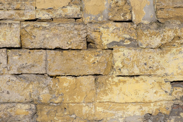 Old and traditionally wall made of cement and stone in various colors and shades. Vintage wall from stones of various shapes, close-up architectural background.