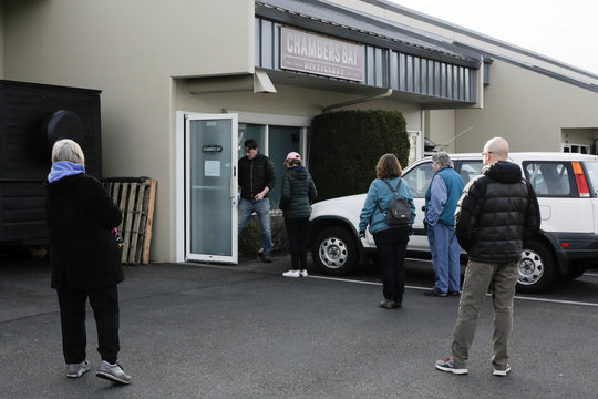 People wait in line for free hands sanitizer at Chambers Bay Distillery, which is creating the product with ethanol alcohol and giving it away, following reports of coronavirus disease (COVID-19) cases in the country, in University Place