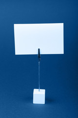 Blank white paper sign over blue background