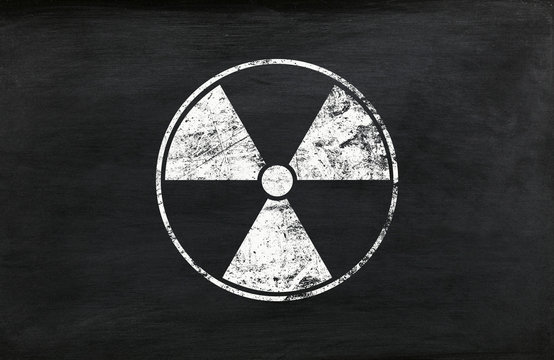 White radioactive sign over black background