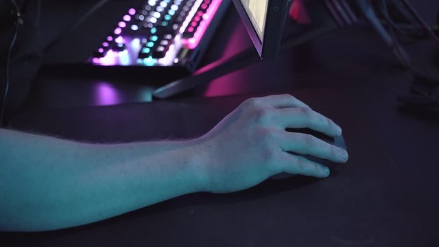 Closeup shot of professional gamer hands playing on keyboard and mouse in dark room. Kyber sport concept