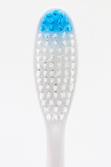 New blue plastic toothbrush on white background. Closeup, selective focus