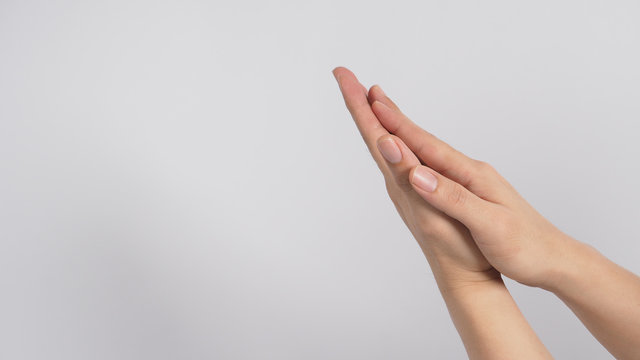 Male model is rubbing hand plams together on white background. - Powered by Adobe