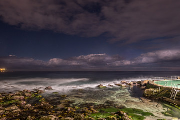 ocean pool, waves and clouds at night