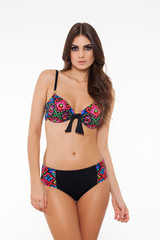 Fototapeta premium beautiful girl posing in stylish detailed colorful bikini on white background.