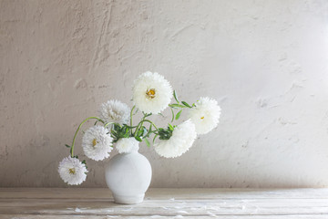 asters in vase on white wooden table