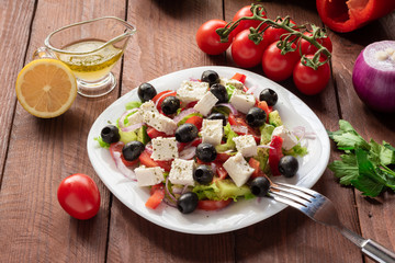 Greek salad with fresh cucumber , tomatoes, sweet pepper, lettuce, red onion, feta cheese and olives with olive oil. Healthy diet