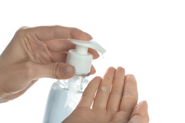 Woman applying antibacterial hand gel against white background, closeup