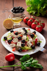 Greek salad with fresh cucumber , tomatoes, sweet pepper, lettuce, red onion, feta cheese and olives with olive oil. Healthy diet
