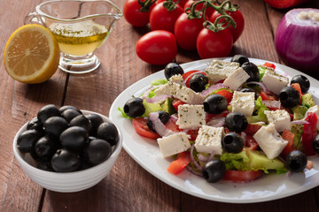 Greek salad with fresh cucumber , tomatoes, sweet pepper, lettuce, red onion, feta cheese and olives with olive oil. Healthy diet