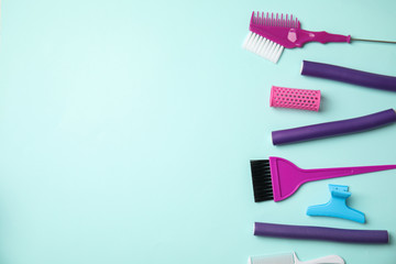 Professional tools for hair dyeing on light blue background, flat lay. Space for text
