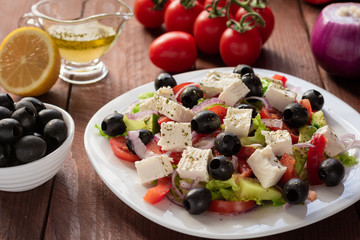 Greek salad with fresh cucumber , tomatoes, sweet pepper, lettuce, red onion, feta cheese and olives with olive oil. Healthy diet