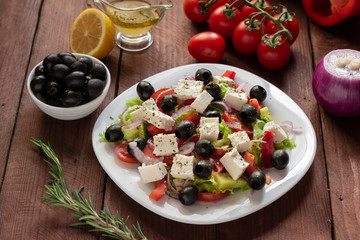 Greek salad with fresh cucumber , tomatoes, sweet pepper, lettuce, red onion, feta cheese and olives with olive oil. Healthy diet