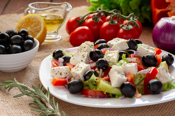 Greek salad with fresh cucumber , tomatoes, sweet pepper, lettuce, red onion, feta cheese and olives with olive oil. Healthy diet