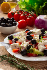 Greek salad with fresh cucumber , tomatoes, sweet pepper, lettuce, red onion, feta cheese and olives with olive oil. Healthy diet