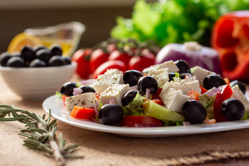 Greek salad with fresh cucumber , tomatoes, sweet pepper, lettuce, red onion, feta cheese and olives with olive oil. Healthy diet