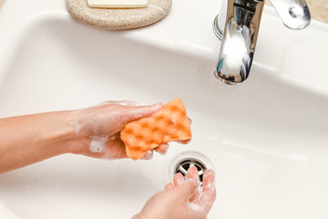 a Washing hands with soap under the faucet with water